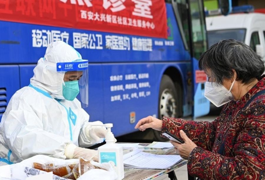 A resident consults a medical worker at a fever clinic in Lianhu District of Xi'an, northwest China's Shaanxi Province, Dec. 21, 2022. Fever clinics have been set up in cities including Xi'an and Changsha to provide timely treatment to patients with COVID-19 symptoms. (Photo by Zou Jingyi/Xinhua)